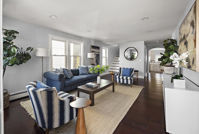 living room with stairway, a baseboard radiator, recessed lighting, arched walkways, and dark wood-type flooring