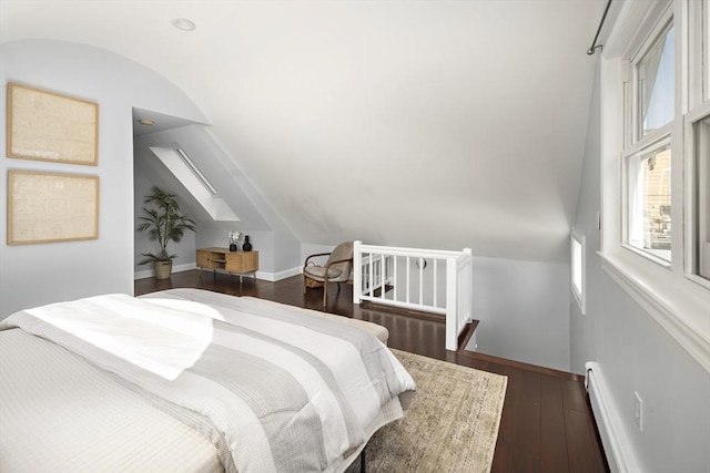 bedroom featuring a baseboard heating unit, baseboards, vaulted ceiling, and hardwood / wood-style flooring