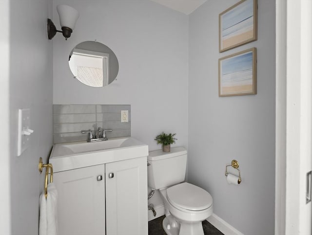 half bath with backsplash, baseboards, toilet, and vanity