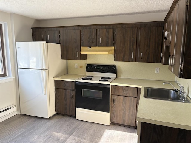 kitchen featuring sink, white appliances, a textured ceiling, and light wood-type flooring