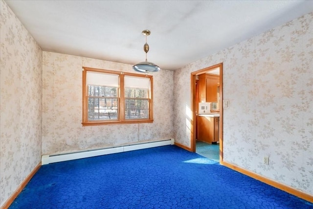 carpeted empty room featuring a baseboard heating unit