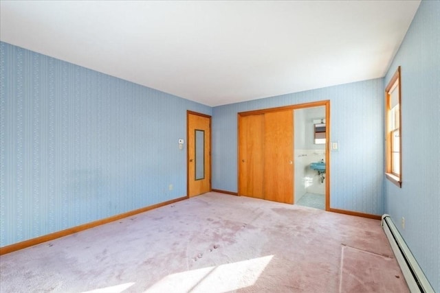 unfurnished bedroom featuring a baseboard heating unit, light colored carpet, and a closet