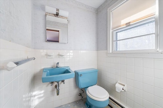 bathroom featuring a baseboard heating unit, sink, and toilet