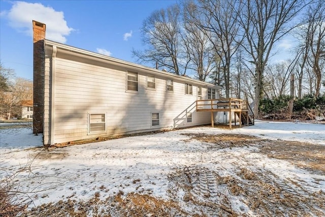 snow covered house featuring a deck