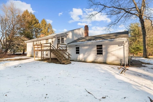 snow covered rear of property featuring a deck