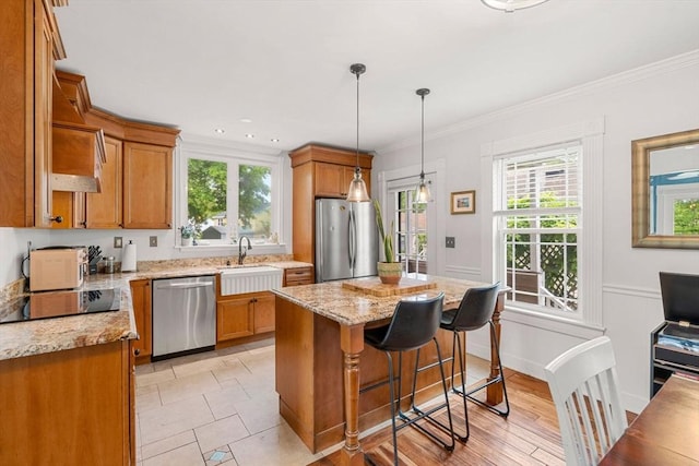 19 Brown Ct, Methuen, MA 01844 - kitchen featuring stainless steel appliances, a sink, brown cabinets, ornamental molding, and recessed lighting