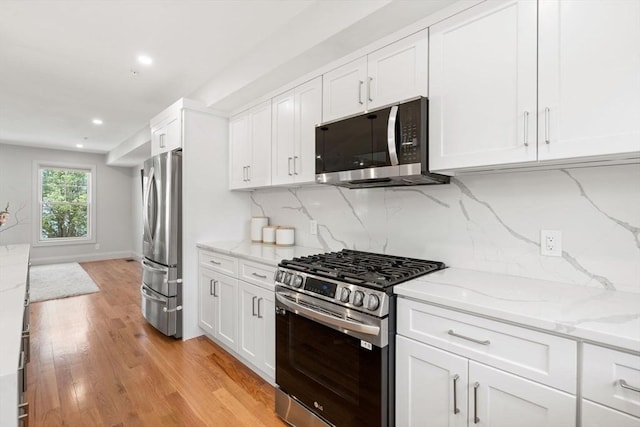114 Broad St Unit D, Weymouth, MA 02188 - kitchen featuring appliances with stainless steel finishes, white cabinetry, light stone counters, decorative backsplash, and recessed lighting
