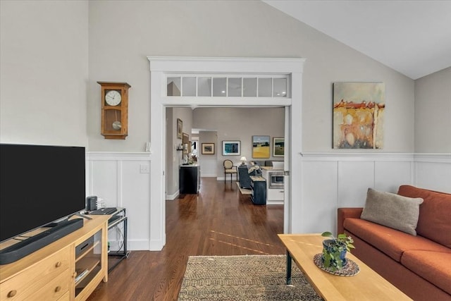 living room featuring dark wood-type flooring and vaulted ceiling