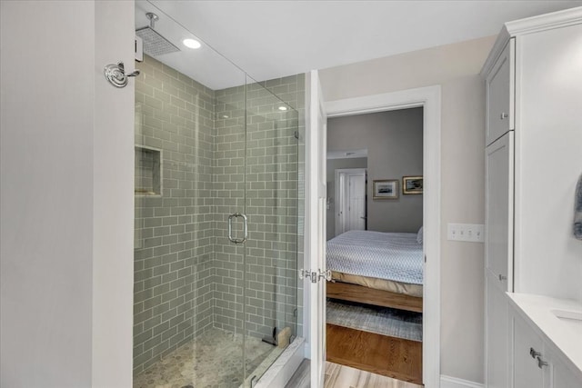 bathroom featuring an enclosed shower, vanity, and wood-type flooring