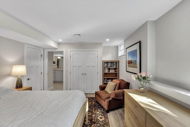 bedroom with light hardwood / wood-style flooring and a closet