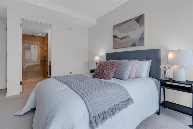 bedroom with light colored carpet and ensuite bath