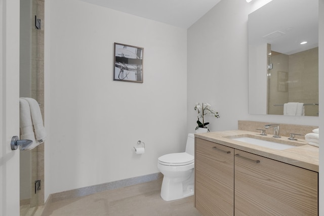 bathroom featuring toilet, a shower with door, and vanity