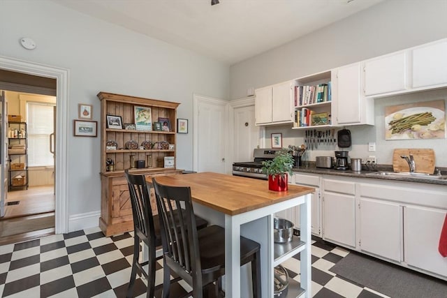 36 7th St, New Bedford, MA 02740 - kitchen featuring open shelves, tile patterned floors, a sink, and white cabinets