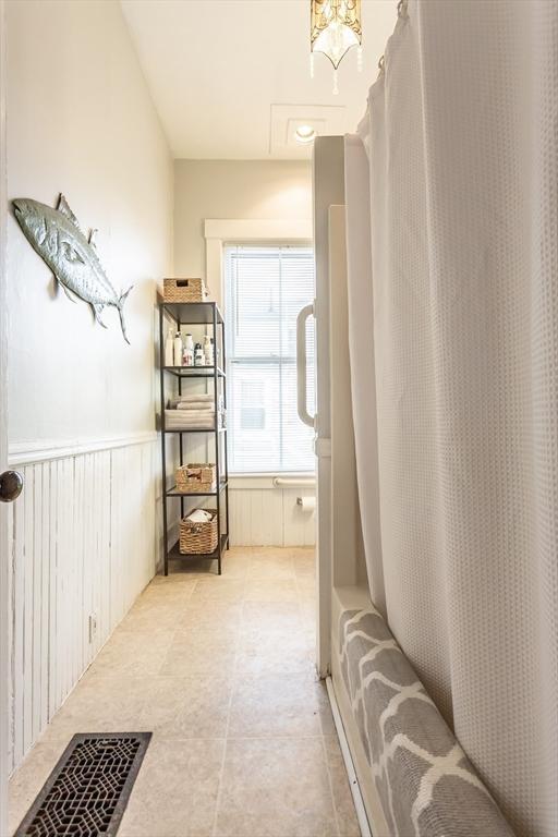 36 7th St, New Bedford, MA 02740 - bathroom with wainscoting and shower / bathtub combination with curtain