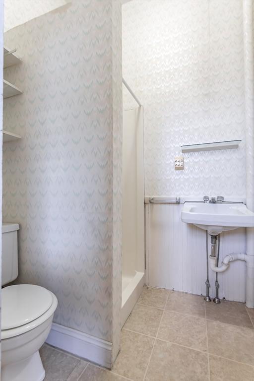 36 7th St, New Bedford, MA 02740 - full bathroom featuring a stall shower, toilet, tile patterned floors, and wallpapered walls