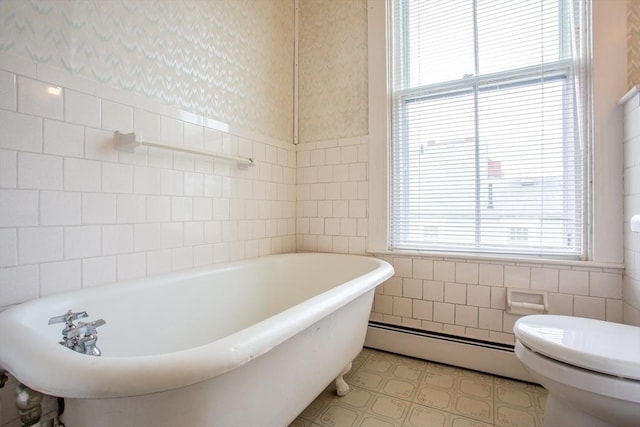 36 7th St, New Bedford, MA 02740 - bathroom with tile walls, a baseboard heating unit, a soaking tub, toilet, and a wainscoted wall