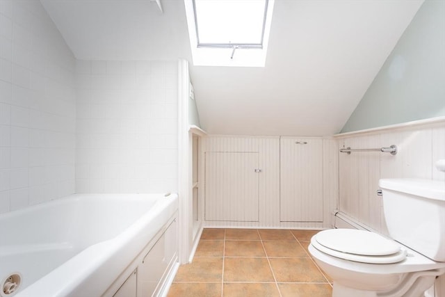 36 7th St, New Bedford, MA 02740 - bathroom featuring lofted ceiling, a tub to relax in, toilet, a skylight, and tile patterned flooring