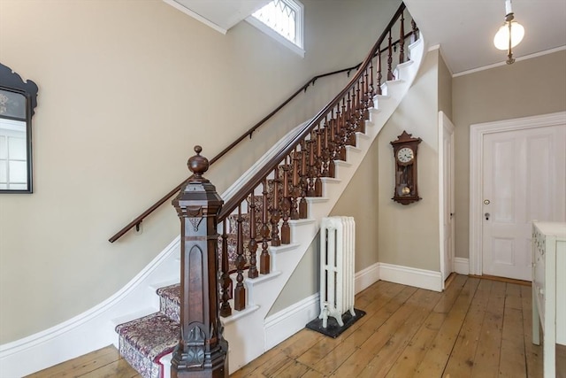 36 7th St, New Bedford, MA 02740 - stairway with radiator, hardwood / wood-style flooring, baseboards, and crown molding