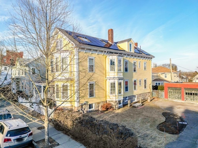 36 7th St, New Bedford, MA 02740 - view of home's exterior featuring a chimney and roof mounted solar panels