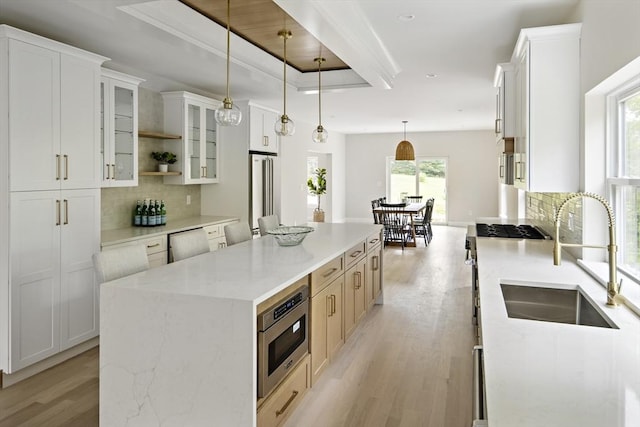 19 Couture Way, Middleton, MA 01949 - kitchen featuring stainless steel appliances, light wood-type flooring, a center island, decorative backsplash, and glass insert cabinets