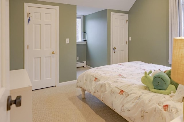 bedroom with baseboard heating and light carpet