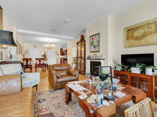 living room featuring an inviting chandelier and light hardwood / wood-style flooring