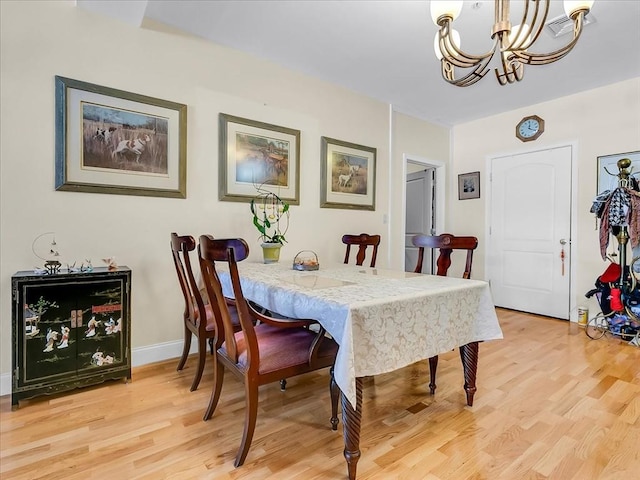 dining space with an inviting chandelier and light wood-type flooring