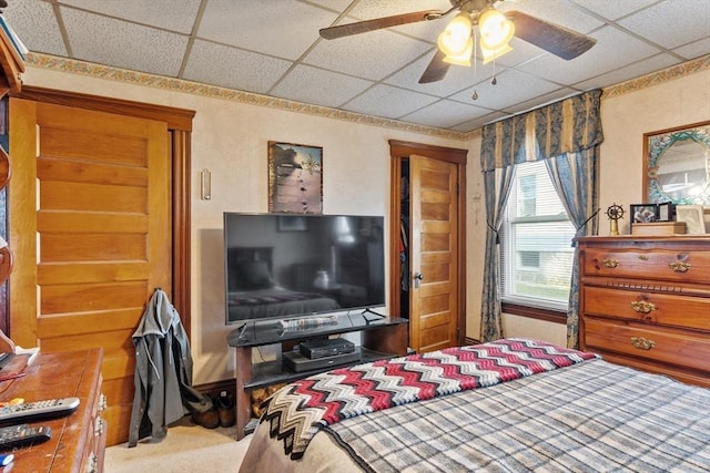 carpeted bedroom with a drop ceiling and ceiling fan