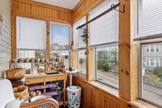 sunroom featuring wood walls
