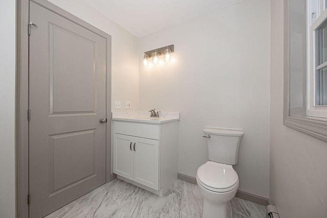 bathroom with toilet, baseboards, vanity, and marble finish flooring