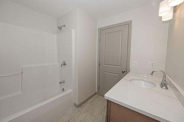 full bathroom featuring tub / shower combination, vanity, marble finish flooring, and baseboards