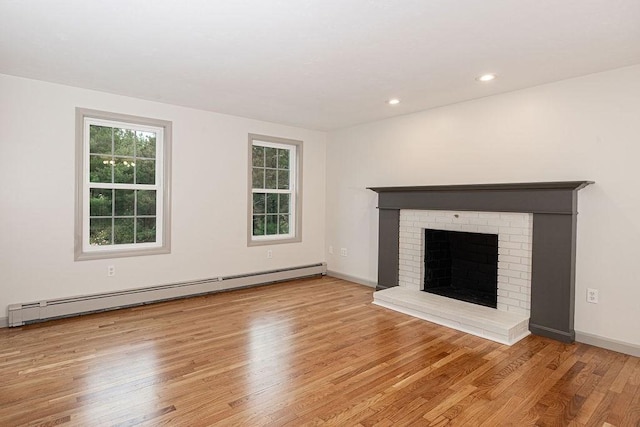 unfurnished living room featuring a baseboard radiator, wood finished floors, a brick fireplace, recessed lighting, and baseboards