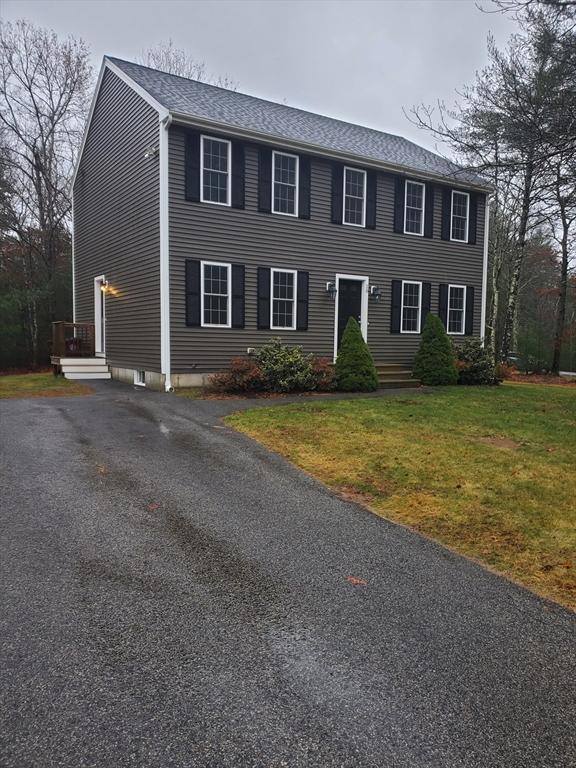 colonial inspired home with a front lawn