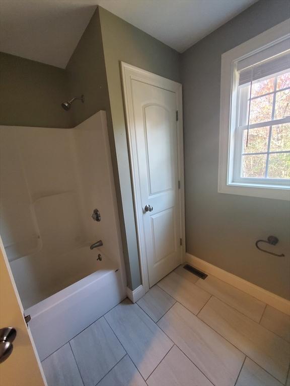 bathroom with tile patterned floors and shower / bathtub combination