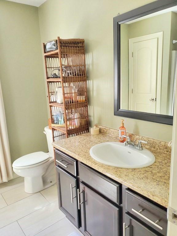 bathroom with tile patterned flooring, vanity, and toilet