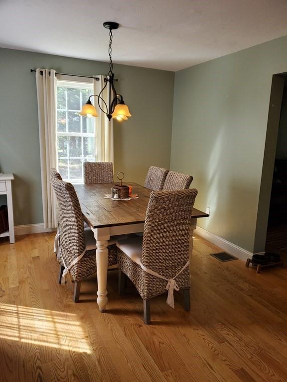 dining room featuring light wood-type flooring and an inviting chandelier