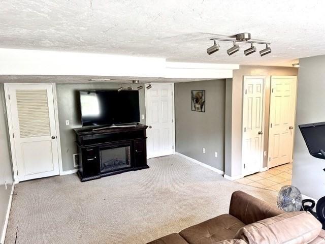 62 Moreland Green Dr, Worcester, MA 01609 - carpeted living room featuring baseboards and a textured ceiling