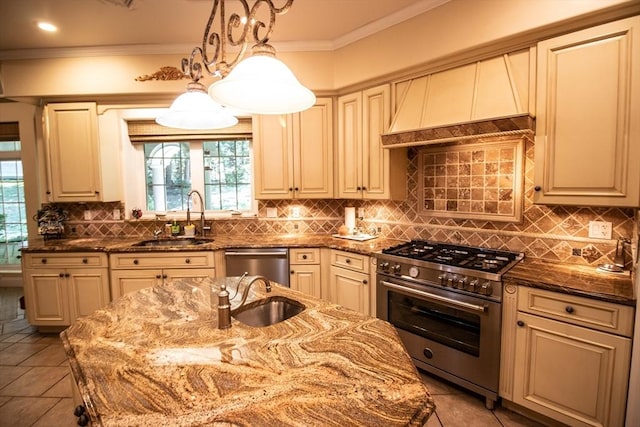 kitchen with appliances with stainless steel finishes, sink, hanging light fixtures, and dark stone countertops