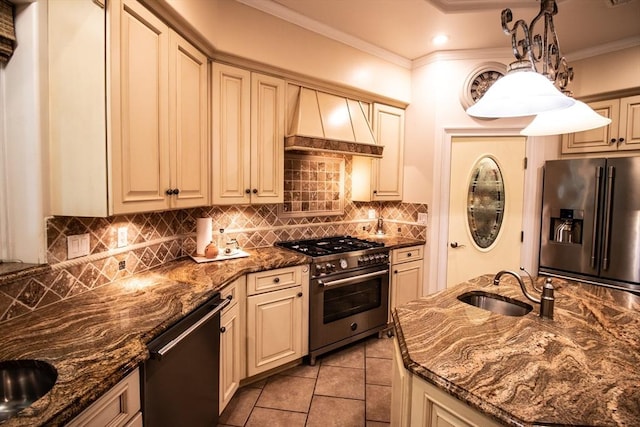 kitchen featuring appliances with stainless steel finishes, decorative light fixtures, dark stone counters, ornamental molding, and custom range hood