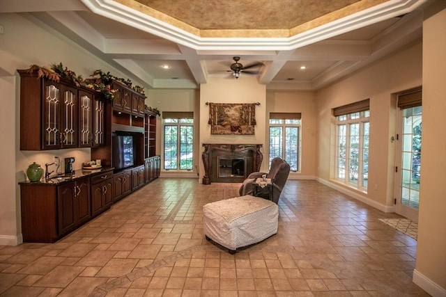 living room featuring coffered ceiling, sink, a towering ceiling, ceiling fan, and beam ceiling