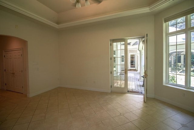 tiled spare room featuring crown molding and a tray ceiling