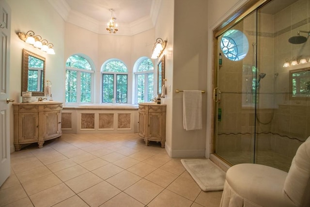 bathroom featuring tile patterned floors, a shower with shower door, an inviting chandelier, ornamental molding, and vanity