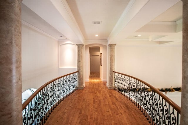 hallway featuring ornamental molding, wood-type flooring, and decorative columns