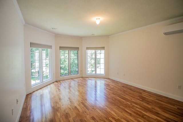 spare room with ornamental molding, a wall mounted AC, and hardwood / wood-style floors