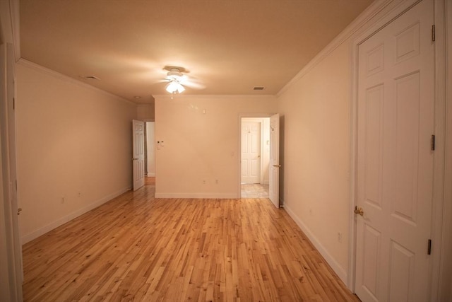 spare room with crown molding and light wood-type flooring