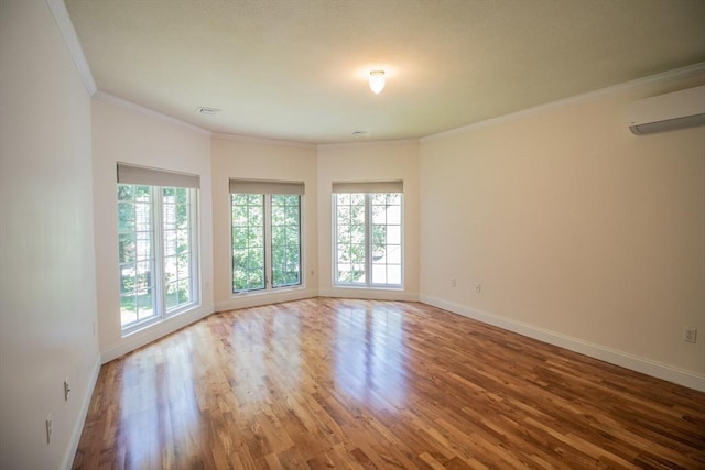 unfurnished room with hardwood / wood-style flooring, crown molding, and a wall mounted air conditioner