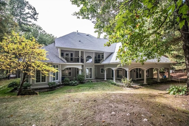 back of house with a balcony and a lawn