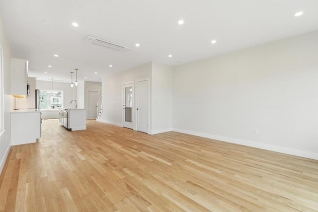77 N End Blvd Unit 2, Salisbury, MA 01952 - unfurnished living room featuring a sink, light wood-style floors, baseboards, and recessed lighting