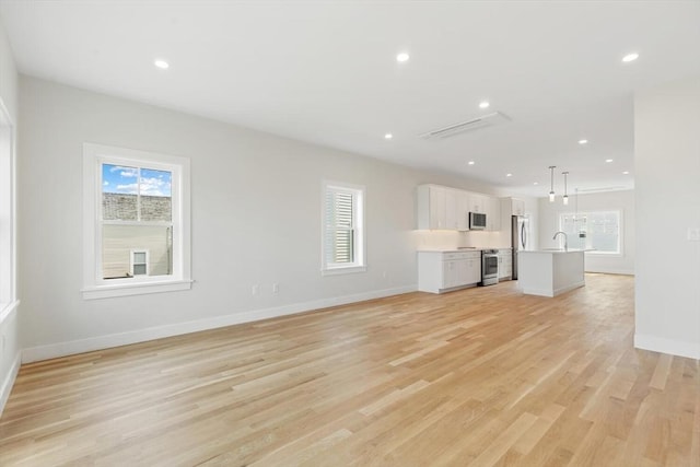 77 N End Blvd Unit 2, Salisbury, MA 01952 - unfurnished living room with a sink, baseboards, recessed lighting, and light wood-style flooring