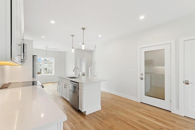 77 N End Blvd Unit 2, Salisbury, MA 01952 - kitchen featuring stainless steel dishwasher, a sink, light countertops, light wood-style floors, and decorative light fixtures